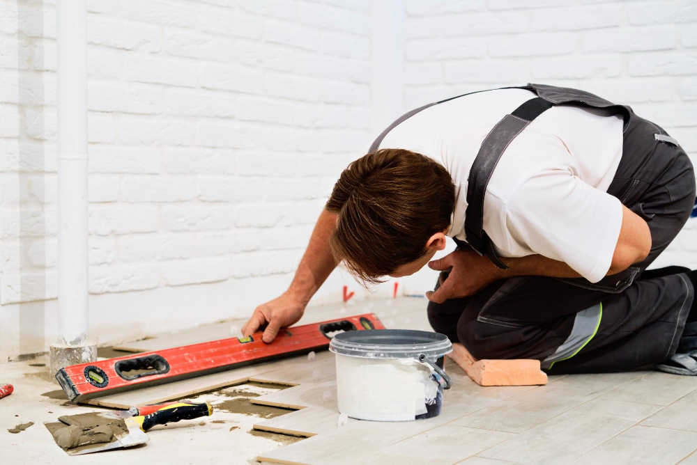 builder-checks-quality-laid-tiles-with-manual-bubble-level-construction-worker-installing-ceramic-floor-tiles-construction-sites-floor-repair-selective-focus