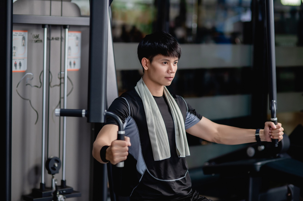 side-view-close-up-portrait-young-handsome-man-sportswear-sitting-doing-machine-chest-press-exercise-modern-gym-looking-forward