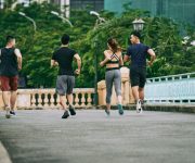 rear-view-three-man-girl-jogging-together-summer-day