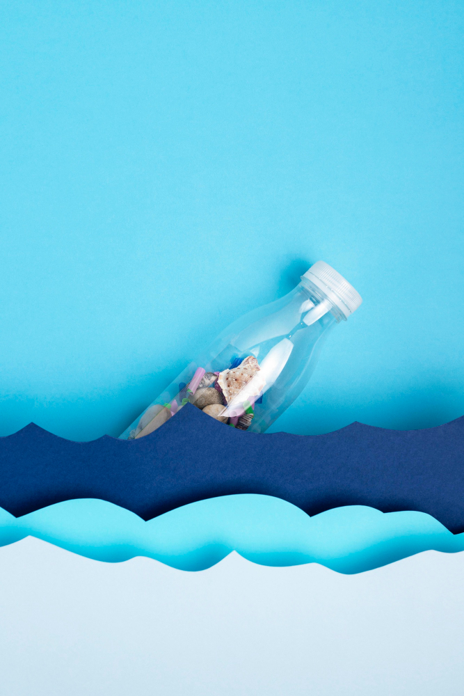 top-view-plastic-bottle-with-paper-ocean-waves