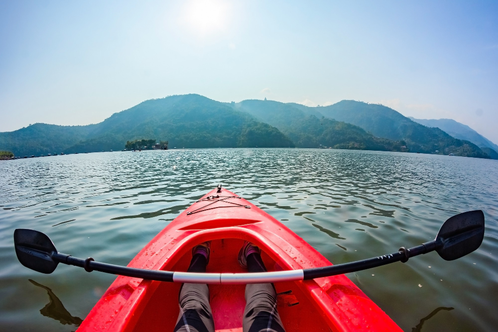 nose-red-kayak-surface-lake-paddle-lying-across-kayak