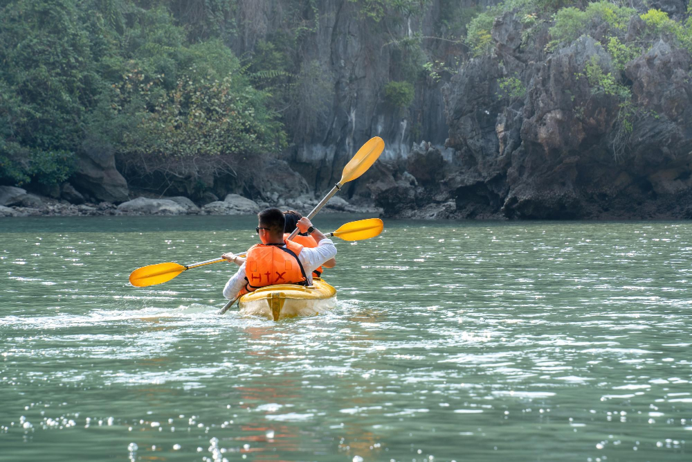 view-tourist-exploring-calm-tropical-bay-with-limestone-mountains-by-kayak-life-people-nature-ha-long-bay-vietnam