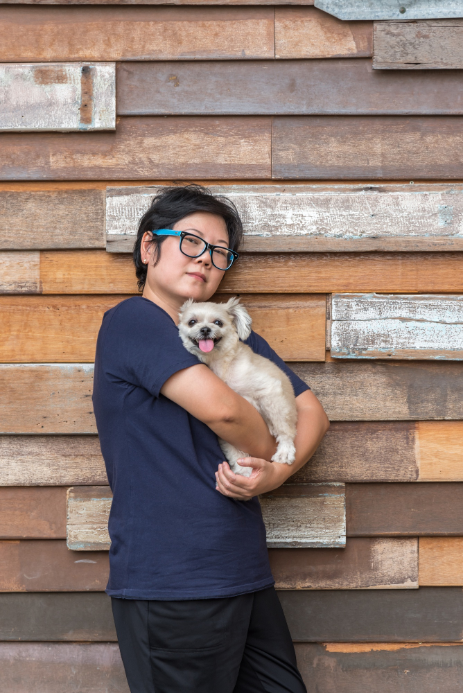 asian-woman-hugging-dog-so-cute-with-wooden-wall