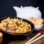 chopsticks-bowl-delicious-noodles-with-beef-wooden-desk