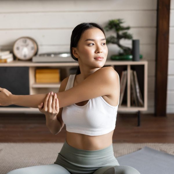 asian-fitness-girl-doing-workout-home-sitting-floor-mat-activewear-warm-up-stretching