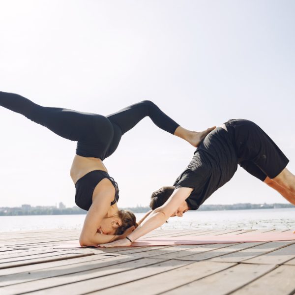 young-sportive-couple-doing-yoga-fitness-people-by-water